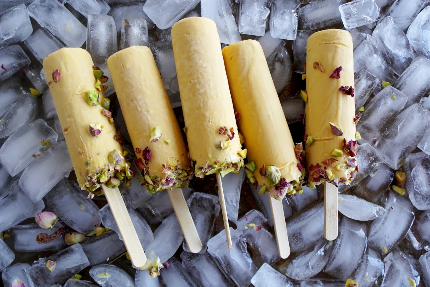 Mango kulfi popsicles with rose petals and pistachios
